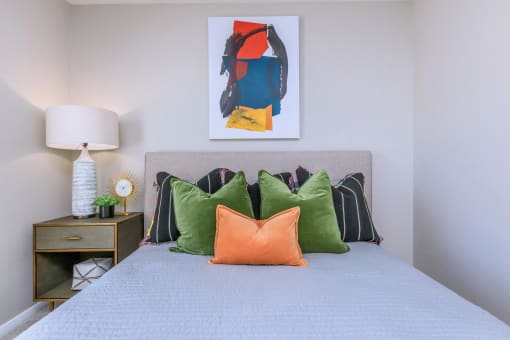 a bedroom with a bed with colorful pillows and a painting on the wall at The Dylan, Murfreesboro, 37129