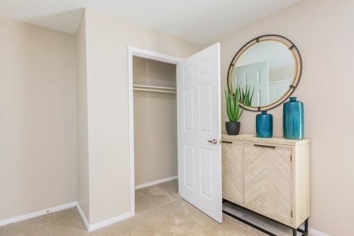 an open door to a closet with a mirror and a dresser at The Dylan, Murfreesboro, TN 37129