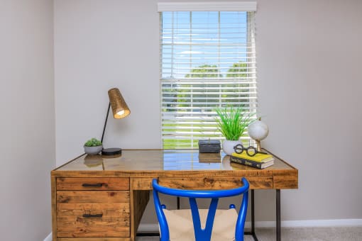 a desk with two blue chairs in a room with a window at The Dylan, Murfreesboro, TN 37129