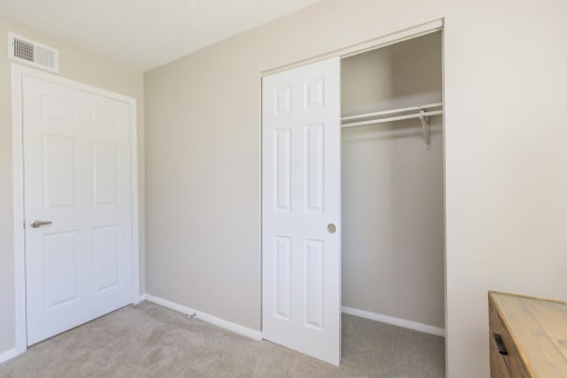 an empty bedroom with a closet and a door to a closet at The Dylan, Murfreesboro, 37129