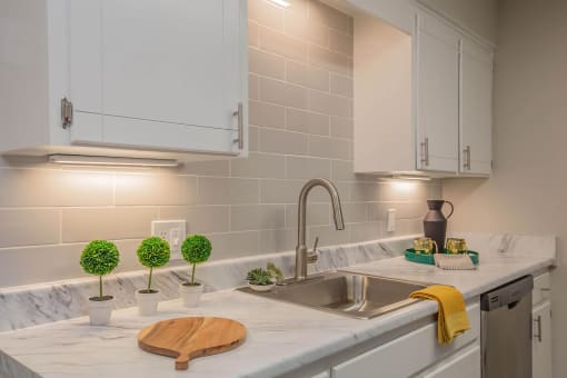 a kitchen with white cabinets and a sink at The Dylan, Murfreesboro 