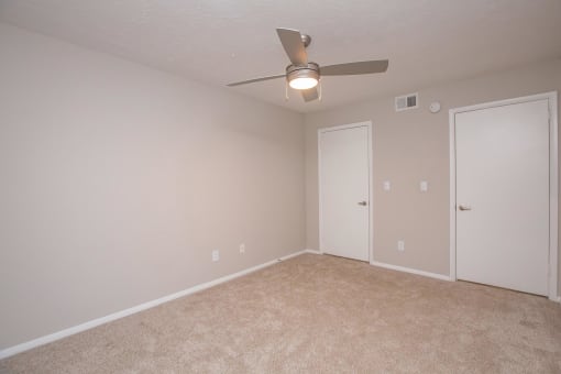 an empty living room with a ceiling fan and a door to a closet at The Dylan, Murfreesboro Tennessee