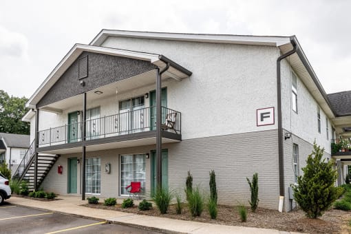 the front of a white building with a balcony and a red mailbox at The Dylan, Murfreesboro