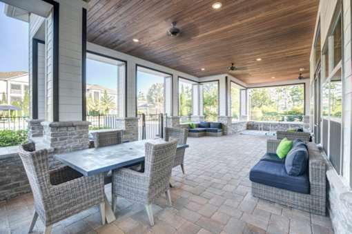 A patio with a table and chairs is surrounded by a stone wall.at Century Ariva, Lakeland, Florida  