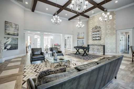 A large, modern living room with a dark leather couch and a fireplace.at Century Ariva, Lakeland, Florida  