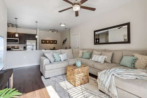 A living room with a couch, a coffee table, and a ceiling fan.at Century Hampton Roads, Suffolk  