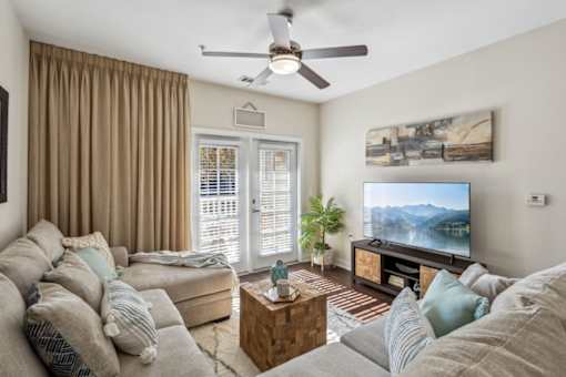 A living room with a grey couch and a flat screen TV.at Century Hampton Roads, Suffolk Virginia  
