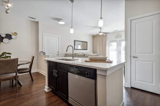 A modern kitchen with a black dishwasher and a wooden floor.at Century Hampton Roads, Virginia, 23435