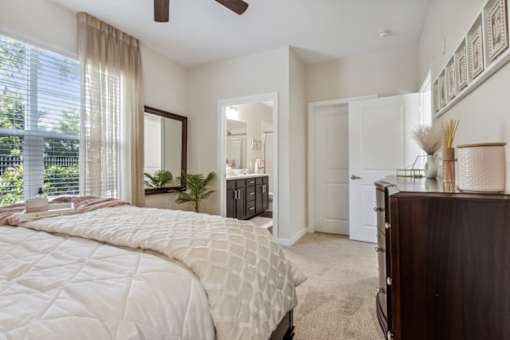 A bedroom with a large bed and a ceiling fan.at Century Hampton Roads, Suffolk  