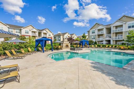 A swimming pool surrounded by lounge chairs and umbrellas in a residential area.at Century Hampton Roads, Virginia  
