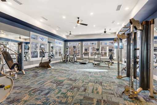 A gym with a variety of equipment including treadmills, weights, and exercise machines.at Century Hampton Roads, Suffolk Virginia  