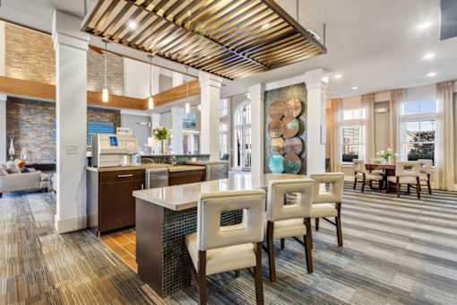 A modern kitchen with a wooden ceiling and a dining area with chairs.at Century Hampton Roads, Virginia  