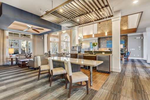 A modern kitchen with a dining table and chairs.at Century Hampton Roads, Suffolk, VA  