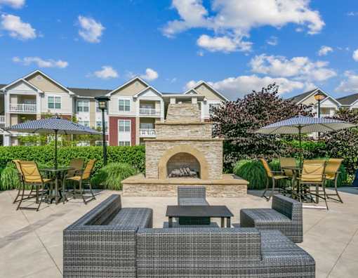 A patio with a fireplace and seating area.at Century Hampton Roads, Suffolk, 23435  