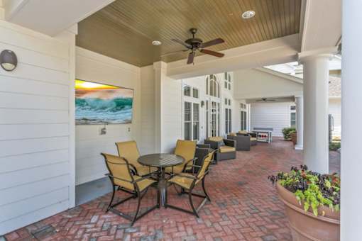 A patio with a table and chairs and a ceiling fan.at Century Hampton Roads, Virginia, 23435