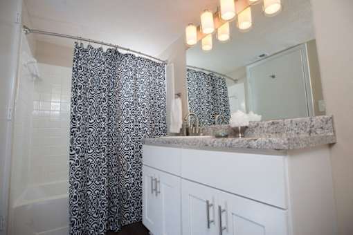 A bathroom with a shower curtain and a counter at Ridge Crossings Apartments, Hoover