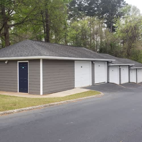 A building with a grey roof and white garage doors.