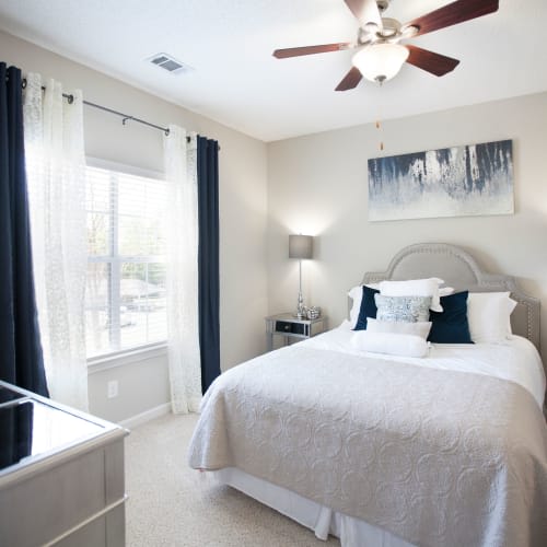 A bedroom with a large bed and a ceiling fan.