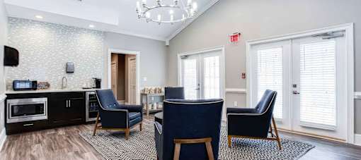 A living room with a black chair and a black and white rug.