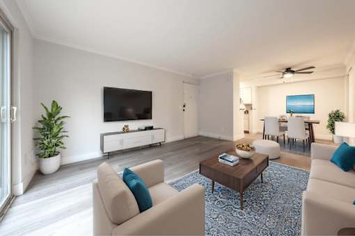 A living room with a large couch, a coffee table, and a flat-screen TV.