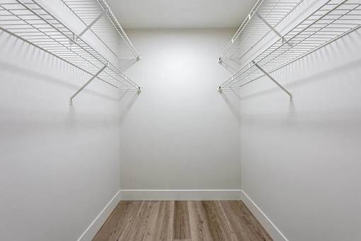 Empty white refrigerator with wood flooring.