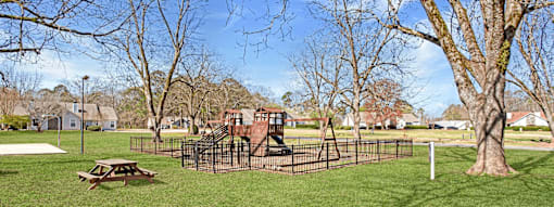 A playground with a slide and a picnic table.