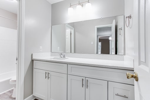 Bathroom with large mirror and storage at Parkside at Sandy Springs Atlanta, GA