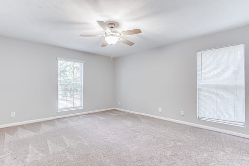 Spacious bedroom with ceiling fan and carpet at Parkside at Sandy Springs Atlanta, GA