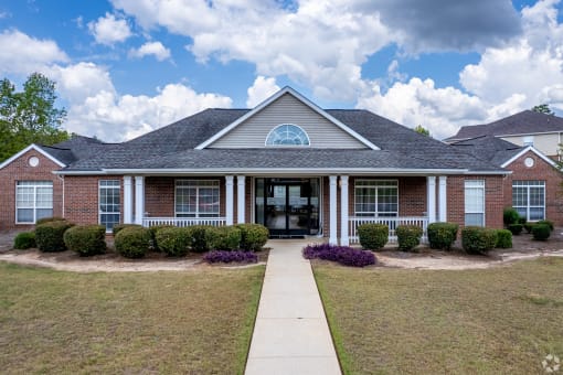 a house with a lawn and a sidewalk in front of it