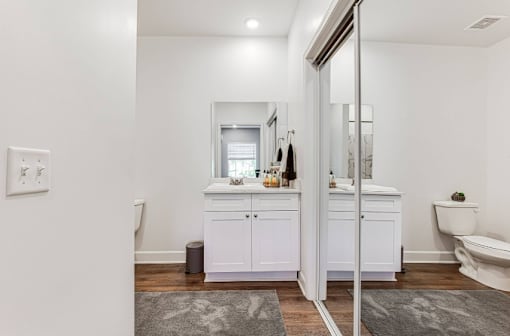 A white bathroom with a vanity and a toilet.