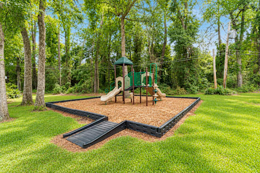 A playground with a slide, swings, and a green dome-shaped structure.