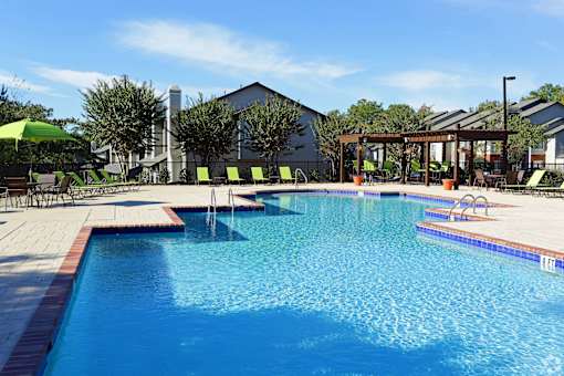 A large swimming pool with a sunny sky in the background.