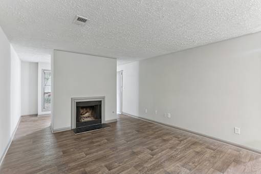 A living room with a fireplace and wood flooring.