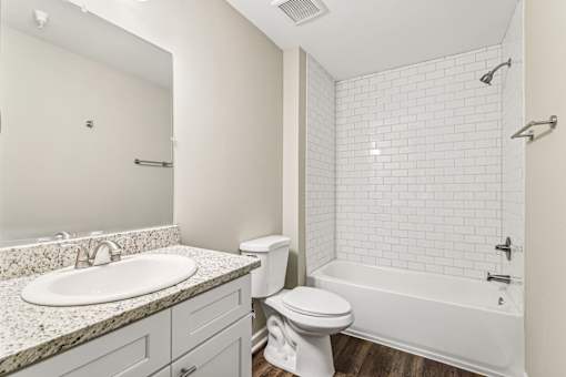 A white bathroom with a sink, toilet, and bathtub.