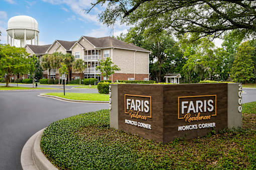 A sign for Faris Residences Moncks Corner stands in front of a building.
