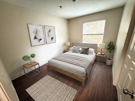 A bedroom with a bed, nightstands, and a rug.