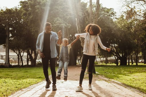 a family walking down a path in a park