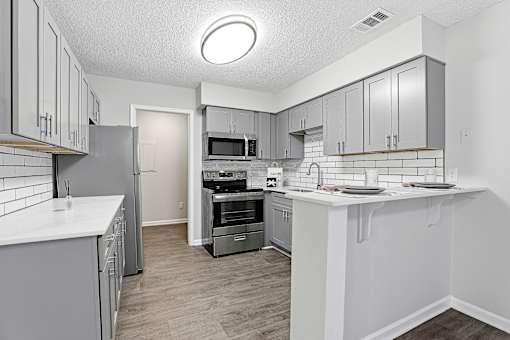A kitchen with white cabinets and a white counter top.