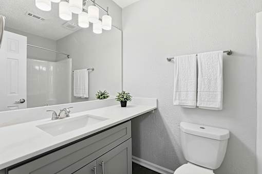 A white toilet sits next to a sink in a bathroom.