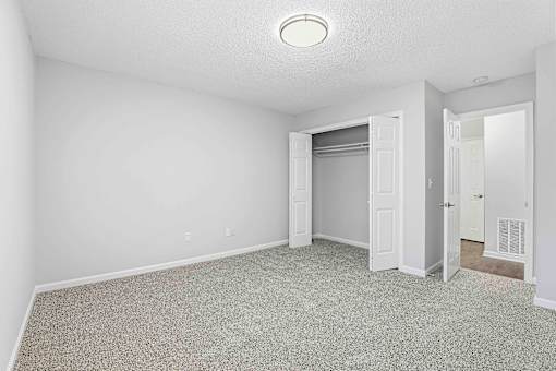 A room with a carpeted floor and a white ceiling light.