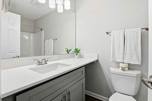 A white toilet sits next to a sink in a bathroom.