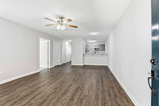 A room with a ceiling fan and lighting fixture.