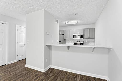 A white kitchen with a white fridge and a white door.