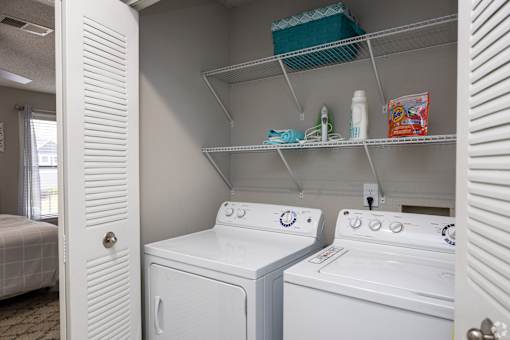 A white washing machine and dryer in a small laundry room.