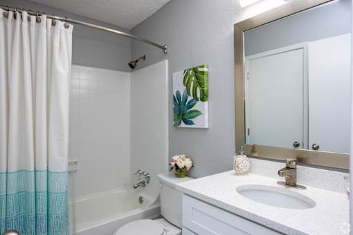 A white bathroom with a white sink and a white toilet.