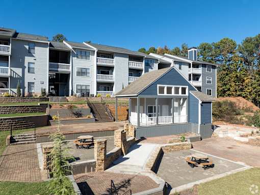 A large apartment complex with a small house in the foreground.