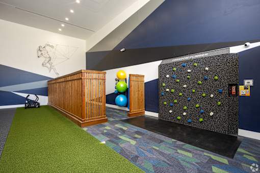 A room with a climbing wall and a wooden podium.