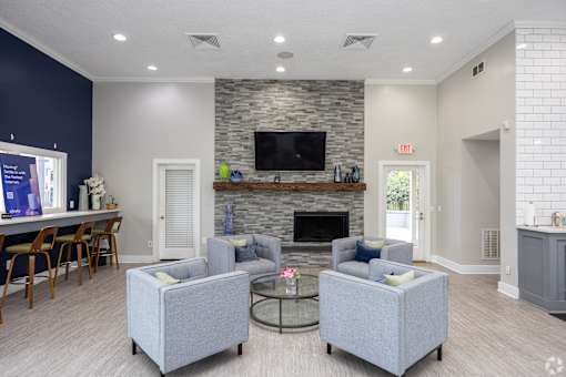 A living room with a grey couch, a fireplace, and a television.