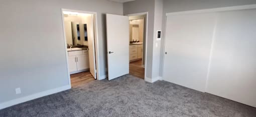 a living room with a carpet and a door to a bathroom