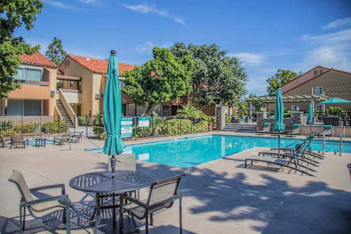 our apartments have a swimming pool with tables and chairs